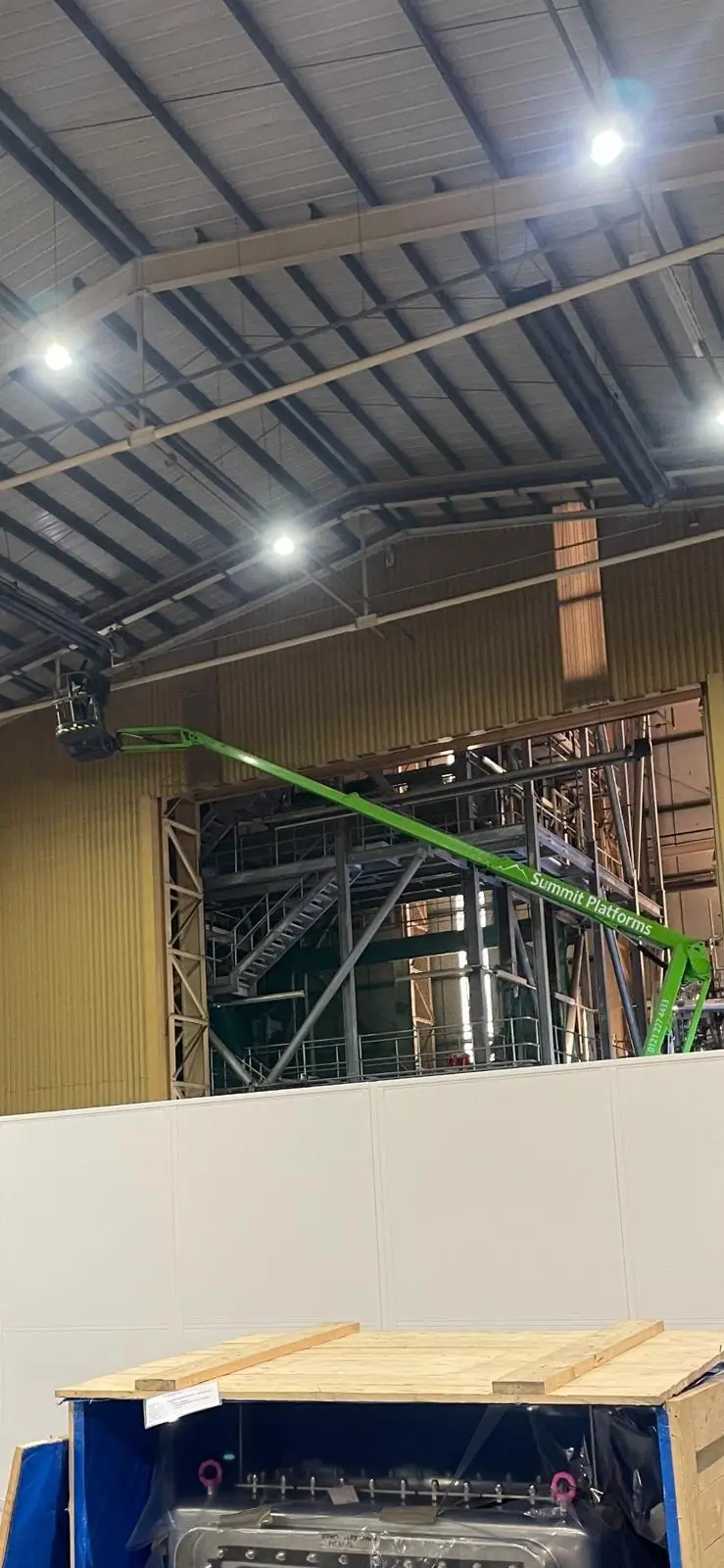 Working at height on a boom lift in a large factory