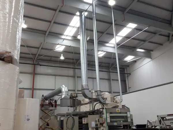 Extraction ductwork installed above production machinery in a factory