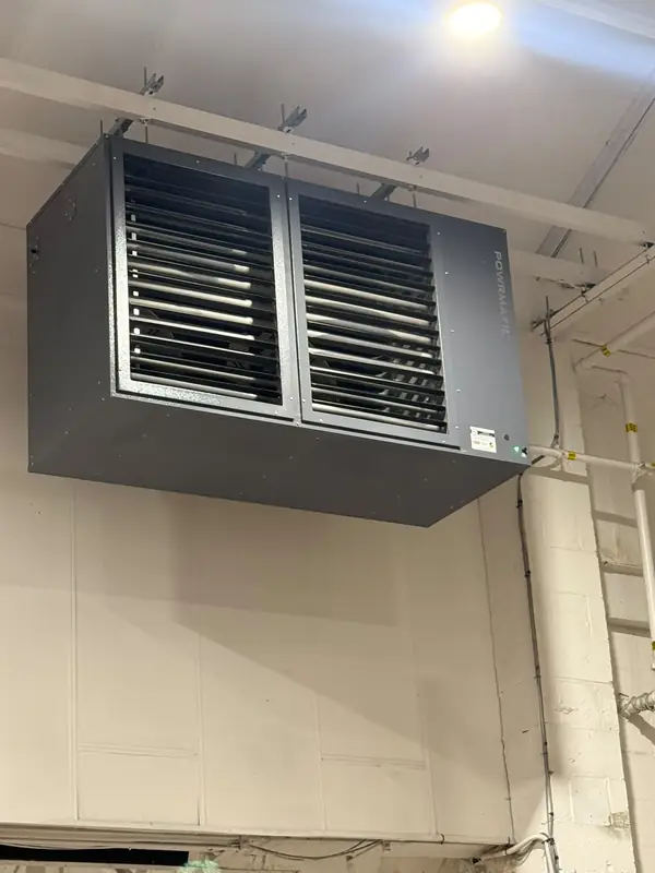 A Powrmatic gas-fired heater suspended from a ceiling